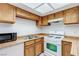 Bright kitchen with wood cabinets, stainless steel sink, and white gas range stove at 875 Rhinegold Way, Las Vegas, NV 89110