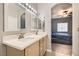 Bright bathroom featuring double sinks, quartz countertops, decorative mirrors, and an archway to the bedroom at 9303 Gilcrease Ave # 1002, Las Vegas, NV 89149