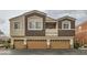 Townhome exterior featuring three car garage and multi-tone stucco at 9303 Gilcrease Ave # 1002, Las Vegas, NV 89149