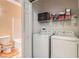 Efficient laundry room with white washer, dryer, utility shelves and adjacent bathroom at 9303 Gilcrease Ave # 1002, Las Vegas, NV 89149