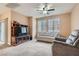 Comfortable living room with a ceiling fan, a large window, and a media center, perfect for relaxation and entertainment at 9303 Gilcrease Ave # 1002, Las Vegas, NV 89149