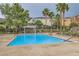 Relaxing community pool with lounge chairs and covered seating area surrounded by lush landscaping and palm trees at 9303 Gilcrease Ave # 1002, Las Vegas, NV 89149