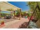 Desert landscaped backyard featuring a covered patio, a dining table, and multiple seating options to enjoy the outdoors at 9370 Corkfish St, Las Vegas, NV 89178