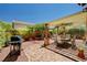 A beautiful backyard patio features a brick surface, a dining table, and a covered pergola in a desert landscaped yard at 9370 Corkfish St, Las Vegas, NV 89178