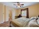 Bright bedroom features a ceiling fan, a window with light filtering shades, and an adjacent bathroom for added privacy at 9370 Corkfish St, Las Vegas, NV 89178