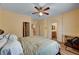 Comfortable bedroom with wood laminate floors, ceiling fan, and neutral colored walls with easy access to a private bathroom at 9370 Corkfish St, Las Vegas, NV 89178