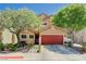 Charming two-story home boasts a vibrant red garage door and mature trees in the landscaped front yard at 9370 Corkfish St, Las Vegas, NV 89178
