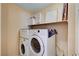 Laundry room equipped with a stacked washer and dryer and built-in shelving for organizing laundry supplies at 9370 Corkfish St, Las Vegas, NV 89178