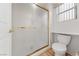Bright bathroom featuring a tiled shower with gold trim and a white toilet at 9917 Arbuckle Dr, Las Vegas, NV 89134
