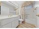 Well-lit bathroom with a large mirror, white vanity, and a shower-tub combination at 9917 Arbuckle Dr, Las Vegas, NV 89134