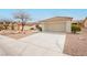 Home's exterior features a wide driveway, neutral color scheme, and low-maintenance landscaping at 10309 Georgetown Pl, Las Vegas, NV 89134