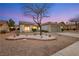 Charming home at dusk with desert landscaping, paved driveway, and a two-car garage at 10309 Georgetown Pl, Las Vegas, NV 89134