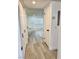 Hallway featuring wood-look flooring, white doors, and leading to a bright living space at 1320 Driscoll Dr # 202, Las Vegas, NV 89128