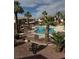 Community pool area surrounded by palm trees, desert landscaping, and nearby buildings at 1320 Driscoll Dr # 202, Las Vegas, NV 89128