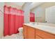 Bright bathroom featuring a vanity with a sink, toilet, and a shower with a red curtain at 1405 Peyton Stewart Ct, North Las Vegas, NV 89086