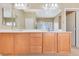 Bathroom featuring a large mirror and dual sinks with wood cabinets and modern fixtures at 1405 Peyton Stewart Ct, North Las Vegas, NV 89086