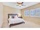 Comfortable bedroom with a large window, ceiling fan, and neutral color scheme at 1405 Peyton Stewart Ct, North Las Vegas, NV 89086