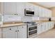 Close-up of the kitchen with stainless steel appliances, white cabinets, and granite countertops at 1405 Peyton Stewart Ct, North Las Vegas, NV 89086