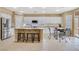 Bright kitchen features white cabinets, stainless appliances, a center island, and adjacent dining area at 1405 Peyton Stewart Ct, North Las Vegas, NV 89086