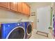 Functional laundry room with modern washer and dryer, storage cabinets, and utility sink at 1405 Peyton Stewart Ct, North Las Vegas, NV 89086