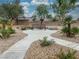A walking path leads to a bench in a peaceful park setting, adorned with desert landscaping and mature trees at 1405 Peyton Stewart Ct, North Las Vegas, NV 89086