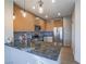 Modern kitchen with wood cabinetry, stainless steel appliances, and a beautiful dark stone breakfast bar at 1510 Fieldbrook St, Henderson, NV 89052