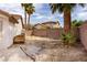 The backyard has palm trees and a brick wall surrounding the perimeter and has a storage box on the side at 1816 Mazzanti Way, Henderson, NV 89014
