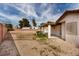 Large backyard with a covered patio, sandy groundcover and surrounded by a red brick fence at 1816 Mazzanti Way, Henderson, NV 89014