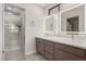 Modern bathroom featuring double sinks, elegant mirrors, and a glass-enclosed shower at 1816 Mazzanti Way, Henderson, NV 89014