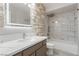 Elegant bathroom featuring a shower over tub, and a modern, lighted mirror over the vanity at 1816 Mazzanti Way, Henderson, NV 89014