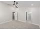 Carpeted bedroom featuring a ceiling fan, doorway to a walk-in closet and an en-suite bathroom at 1816 Mazzanti Way, Henderson, NV 89014