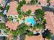 Aerial view of the community pool and hot tub, palm trees and nearby condo buildings with red tile roofs at 1830 N Buffalo Dr # 2014, Las Vegas, NV 89128