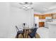 Bright kitchen area with a glass table, ceiling fan and white appliances at 1830 N Buffalo Dr # 2014, Las Vegas, NV 89128