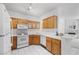 Bright kitchen with wood cabinets, white appliances and countertops with adjacent breakfast bar at 1830 N Buffalo Dr # 2014, Las Vegas, NV 89128