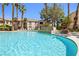Large community swimming pool with lounge chairs and a rock fountain at 1830 N Buffalo Dr # 2014, Las Vegas, NV 89128