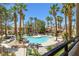 Community pool area surrounded by palm trees offering a relaxing outdoor space at 1830 N Buffalo Dr # 2014, Las Vegas, NV 89128