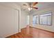 Well-lit bedroom with a ceiling fan, wood floors, and a large window with natural light at 1850 Camino Verde Ln, Las Vegas, NV 89119