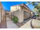 A single-story home with stucco exterior, a brown garage door and an enclosed courtyard entryway at 1850 Camino Verde Ln, Las Vegas, NV 89119