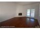 A spacious living room featuring hardwood floors, white-painted brick fireplace, and glass doors at 1850 Camino Verde Ln, Las Vegas, NV 89119