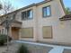 Desert townhome showcases a stucco exterior with tiled roof, desert landscaping, and gated windows at 2121 Hussium Hills St # 107, Las Vegas, NV 89108