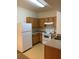 Galley kitchen features white appliances, wood cabinets, and laminate countertops at 2121 Hussium Hills St # 107, Las Vegas, NV 89108