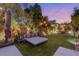 Lush backyard oasis with lounge area, mature trees, and landscape lighting at 2240 Boutique Ave, Henderson, NV 89044