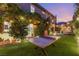 A ping pong table sits on the green grass in this beautiful backyard with mature landscaping at 2240 Boutique Ave, Henderson, NV 89044
