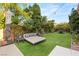 Serene backyard with manicured lawn, comfortable seating, and mature landscaping at 2240 Boutique Ave, Henderson, NV 89044