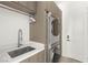 Convenient laundry room with modern washer and dryer units, built-in sink, and ample storage space at 2240 Boutique Ave, Henderson, NV 89044