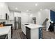 Well-lit kitchen featuring modern appliances, a center island, and adjacent stairway at 25 Barbara Ln # 36, Las Vegas, NV 89183