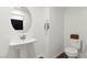 Cozy powder room featuring a pedestal sink, toilet, and wood-look flooring at 25 Barbara Ln # 36, Las Vegas, NV 89183