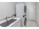 Contemporary laundry room featuring a stacked washer and dryer and a utility sink at 271 E Shelbourne Ave, Las Vegas, NV 89123
