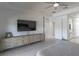 Spacious main bedroom with light wood-look floors, tv, dresser, and ensuite bathroom with closet at 271 E Shelbourne Ave, Las Vegas, NV 89123