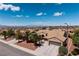 Scenic aerial view of a well-maintained home with a three-car garage, desert landscaping, and palm trees at 2752 Fort Myer Ave, Henderson, NV 89052